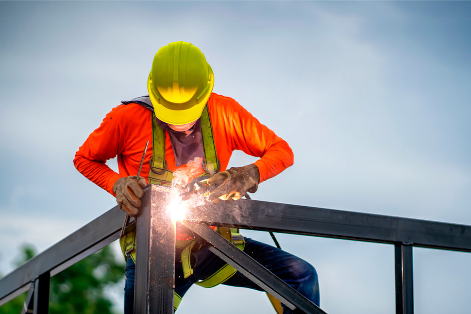 steel worker doing welding, wearing security equipment.