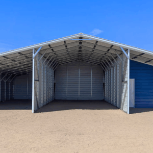 Front view of a metal barn in Arlington Heights, IL with a center enclosed garage, open lean-to sections on both sides, and a blue accent wall with a walk-in door and window.