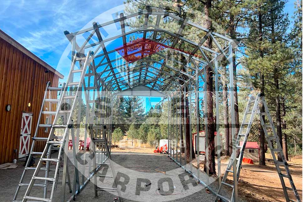 Construction of a metal structure is underway in a forested area, representing fall carport upgrades in Arkansas.