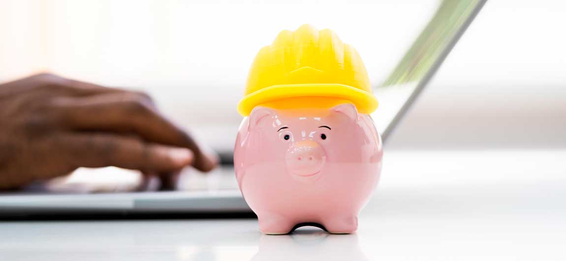 A piggy bank topped with a construction helmet, representing funding options for a custom steel workshop in Oklahoma.